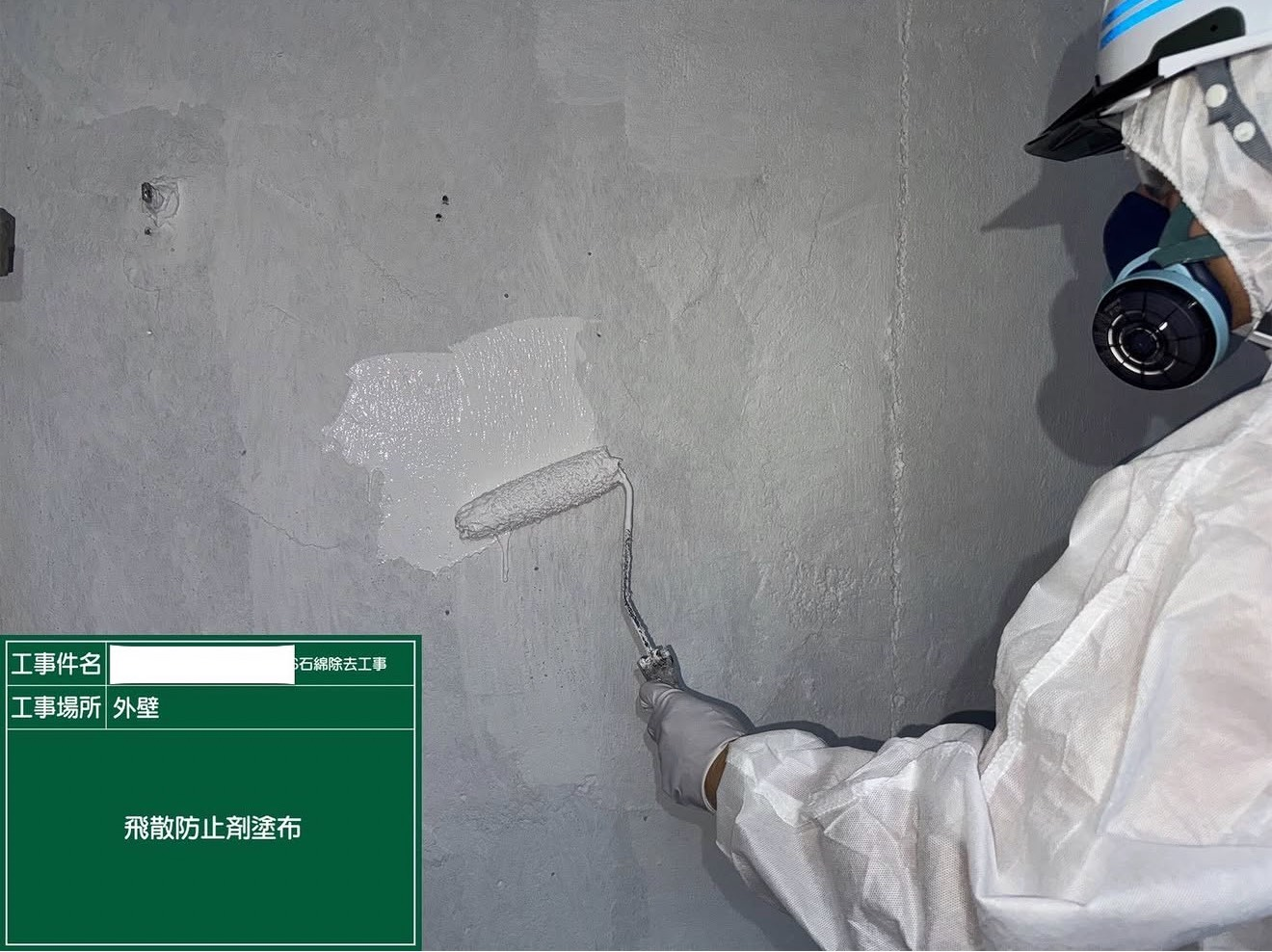アスベスト除去後の外壁へ飛散防止剤を塗布する作業